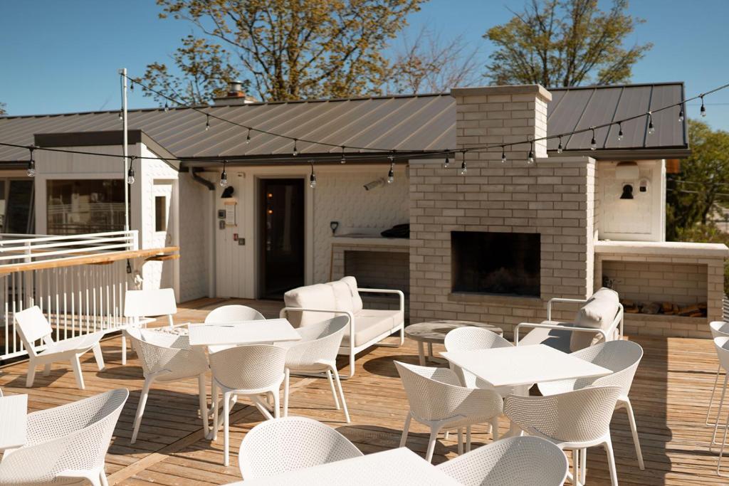 a patio with white tables and chairs on a deck at The Beach Motel in Southampton