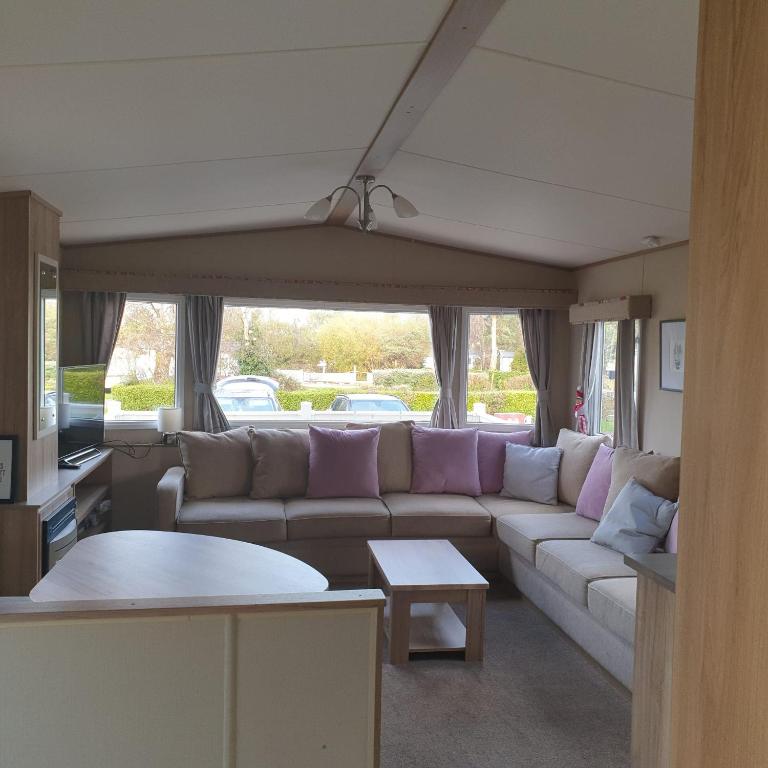a living room with a couch and a table at Caravan under the tree in Port Seton