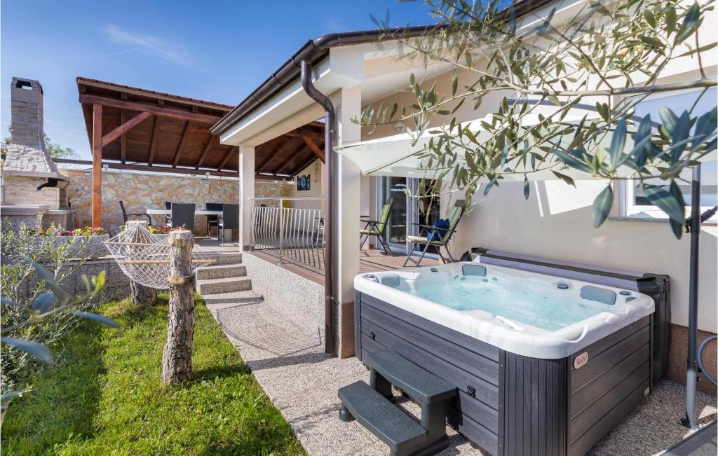 a hot tub in the backyard of a house at Nice Home In Valbandon With Jacuzzi in Valbandon