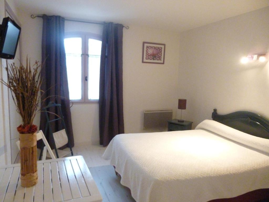 sypialnia z łóżkiem, oknem i telewizorem w obiekcie Auberge de la Table Ronde w mieście Vinon-sur-Verdon
