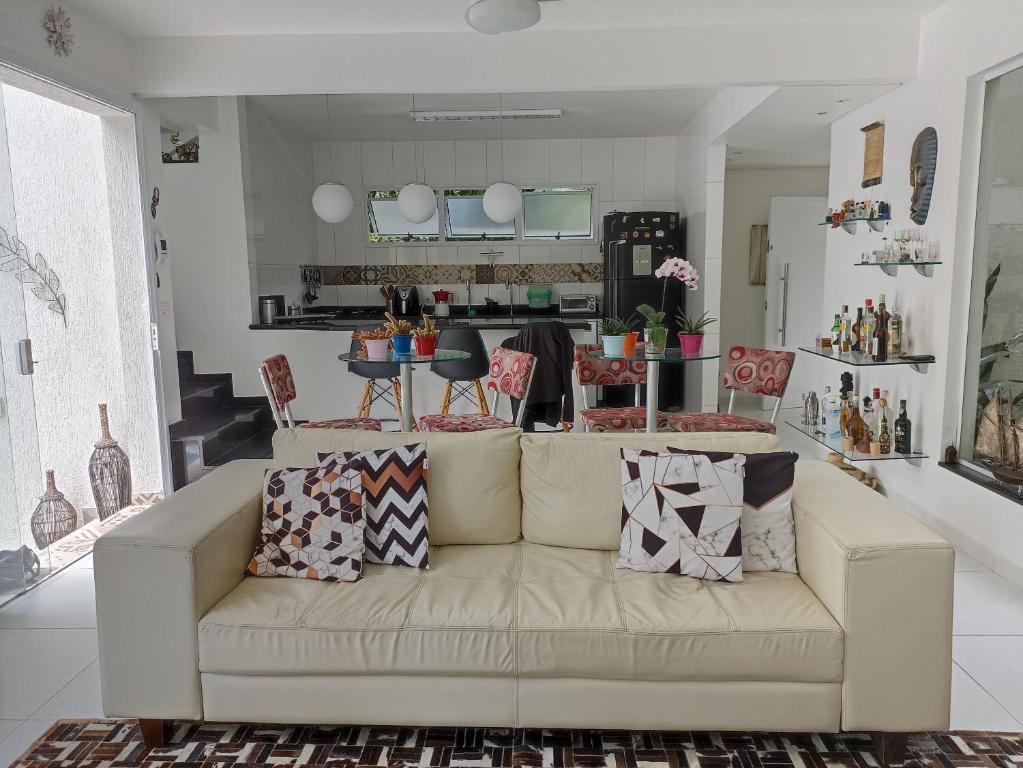 - un salon avec un canapé et des oreillers dans l'établissement Casa Barra do Una Sol, Mar e Cahoeiras, à São Sebastião