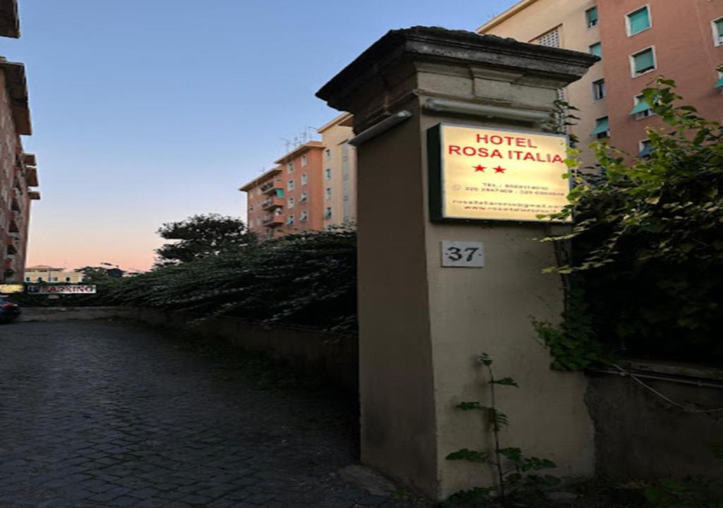 ローマにあるRosa Italia Hotel Romaの川の横に看板のある建物