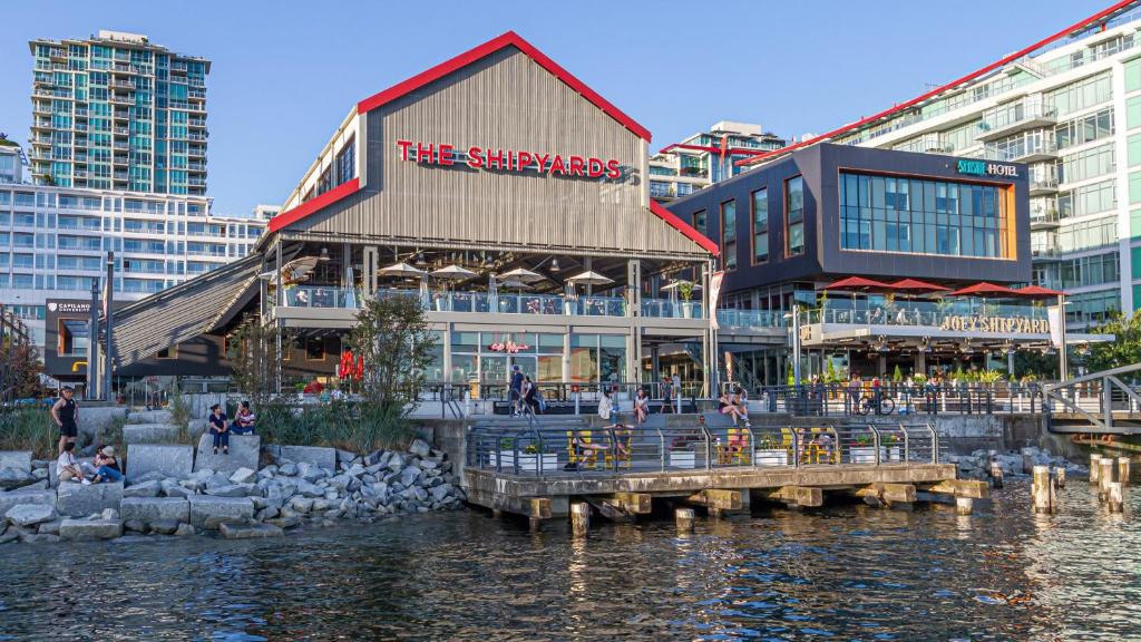 un edificio junto a una masa de agua con edificios en Seaside Hotel North Vancouver, en North Vancouver