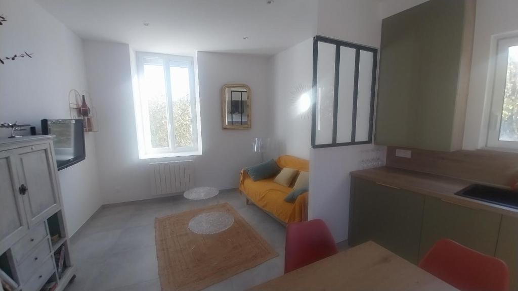 - un salon avec un canapé jaune et des fenêtres dans l'établissement Location saisonnière gap hautes alpes, à Gap