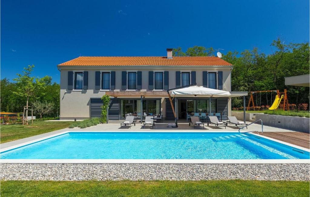 une villa avec piscine devant une maison dans l'établissement Villa Povetica, à Poreč