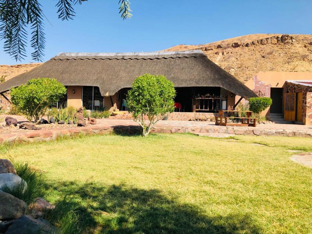 a house with a grass yard in front of it at Hais Ra Tented Campsite in Khorixas