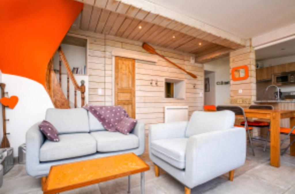 un salon avec deux chaises blanches et une table dans l'établissement Le repos au bord du cher, à Saint-Avertin