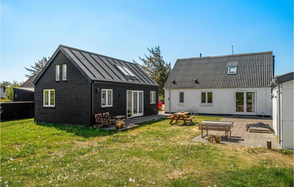 a black house and a white house and a yard at Holiday Home Stenbjerg Kirkevej in Stenbjerg