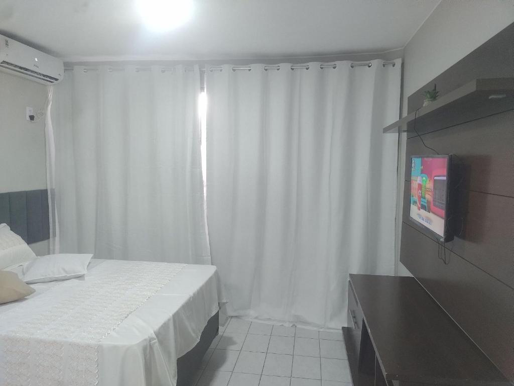 a hotel room with a bed and a television at Apto 352 centro nucleo bandeirant in Brasilia