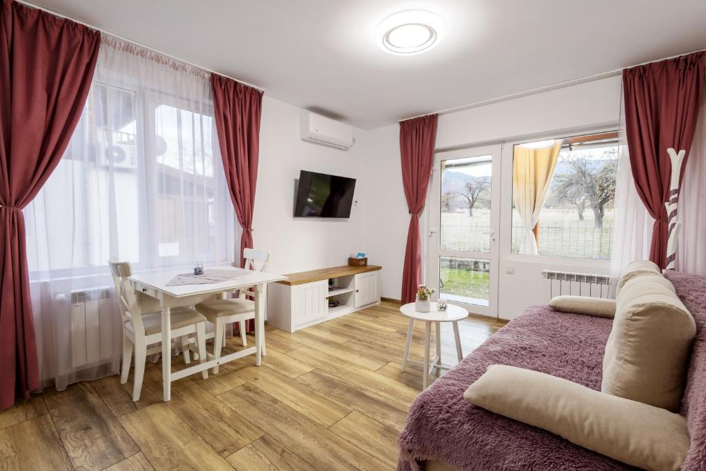 a living room with a bed and a table and a desk at Villa Nikol Apartment #1 in Raduil