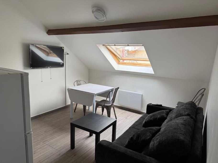 a living room with a couch and a table at Appartement J, RESIDENCE DU RENOUVEAU, Stade de France, idéal pour 4 pers in Saint-Denis