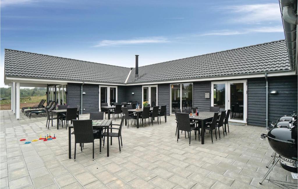 a patio with tables and chairs and a building at Nice Home In Spøttrup With Sauna in Spottrup