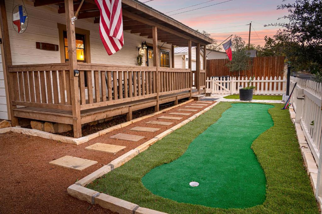 a house with a putting green in front of a house at LeMay Haus - Fire Pit, Heated Pool & Close to Main in Fredericksburg