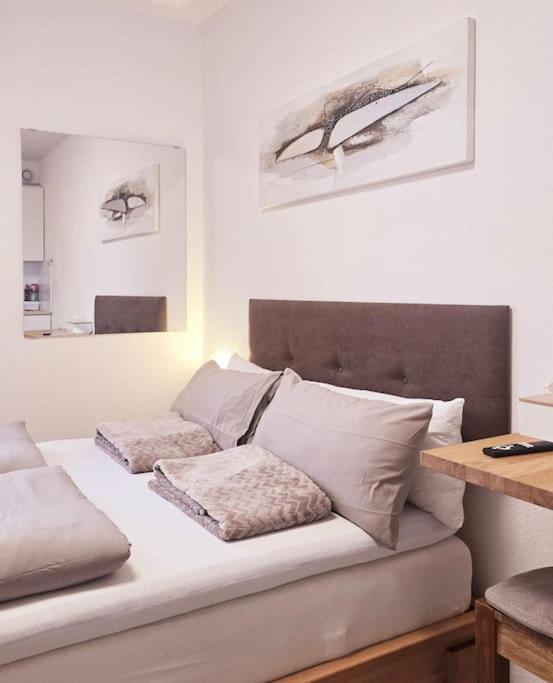a bed with two pillows on it in a room at City Lage mit Rheinblick in Mainz