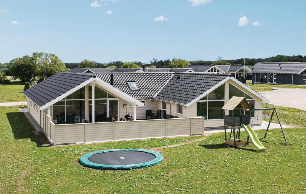 una casa con un trampolino e un parco giochi di 5 Bedroom Awesome Home In Bogense a Skåstrup