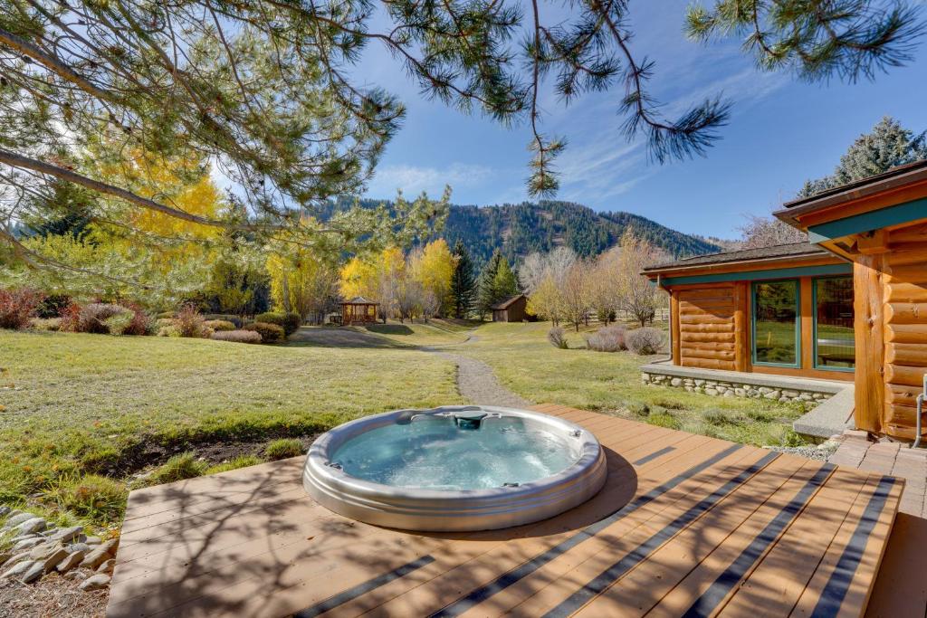 サンバレーにあるSun Valley Log Home with Hot Tub and Mtn Views!の庭園のテーブルに座ってホットタブを利用できます。