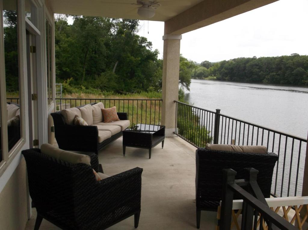 un porche avec un canapé et des chaises et une vue sur une rivière dans l'établissement Mystic Dream, à Hot Springs