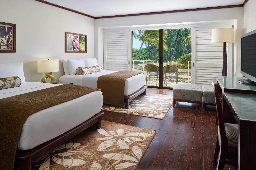 a hotel room with two beds and a balcony at Lotus Honolulu at Diamond Head in Honolulu