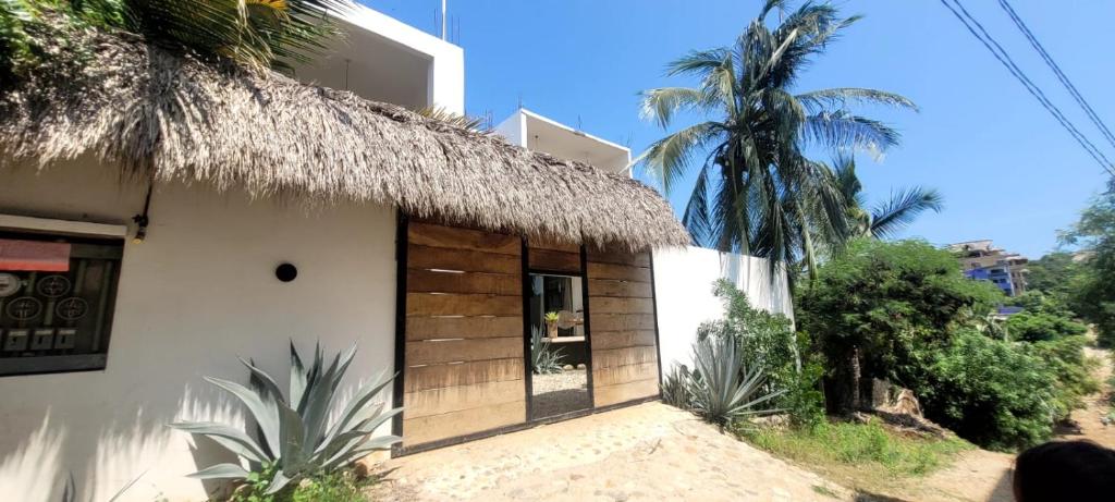 una piccola casa con tetto di paglia e palma di Dada Hotel a Brisas de Zicatela