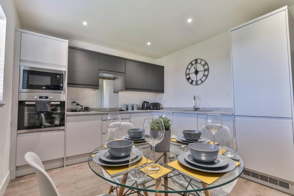 a kitchen with a glass table with chairs and a clock at Modern, Cosy Whole House Wifi Close To Attractions in Sheffield