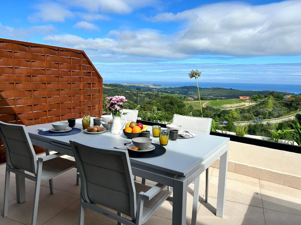 a white table and chairs on a balcony at El Balcón de Oyambre - Vistas al mar y montaña in Canales