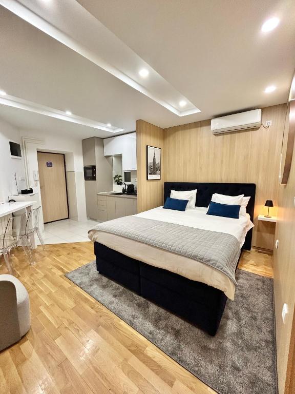 a bedroom with a large bed with blue pillows at Paradise Museum City Center in Belgrade