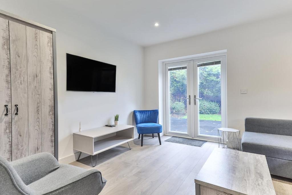 a living room with a couch and a chair and a tv at 3 Bed Refurbished, Modern House, Wifi, Patio Area in Sheffield