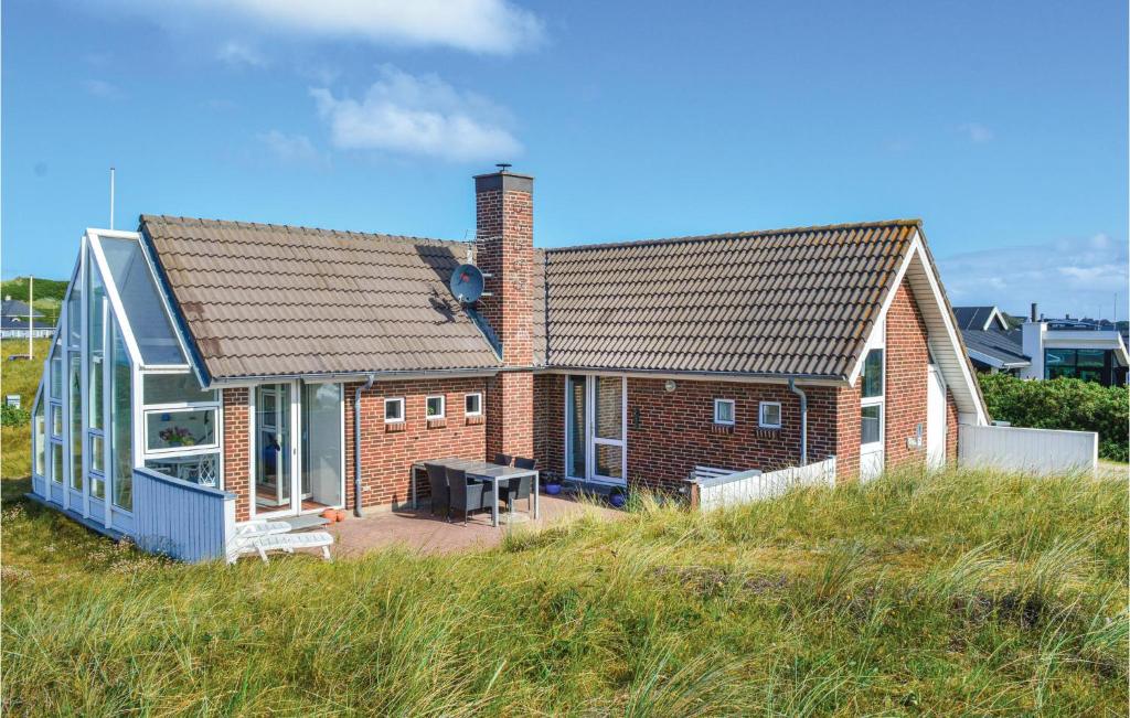 a brick house with a conservatory on a beach at Holiday Home Ringkøbing With Fireplace Ii in Ringkøbing