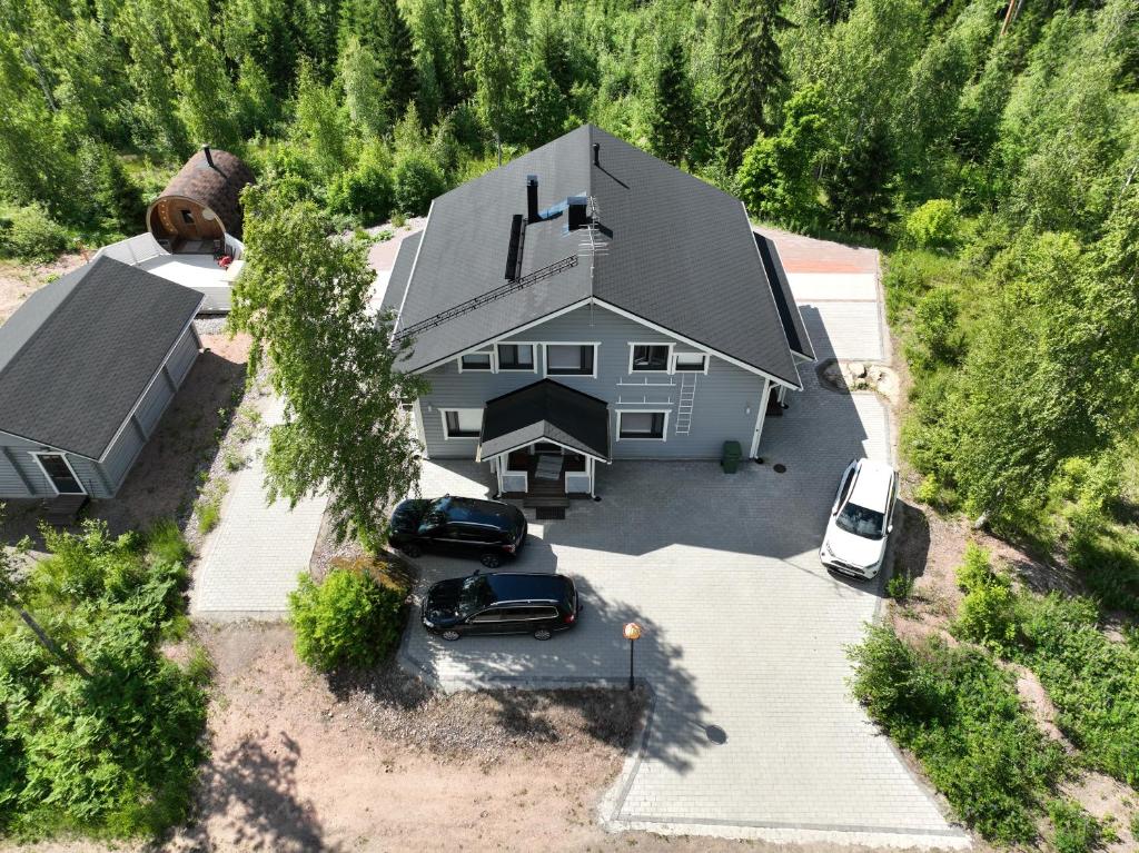 Draufsicht auf ein Haus mit zwei davor geparkten Autos. in der Unterkunft Matikkala Cottages in Ruokolahti