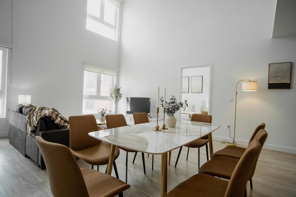 a dining room with a white table and chairs at Chic Urban Retreat in Heart of LA, 2 Bedroom and 1 Loft in Los Angeles