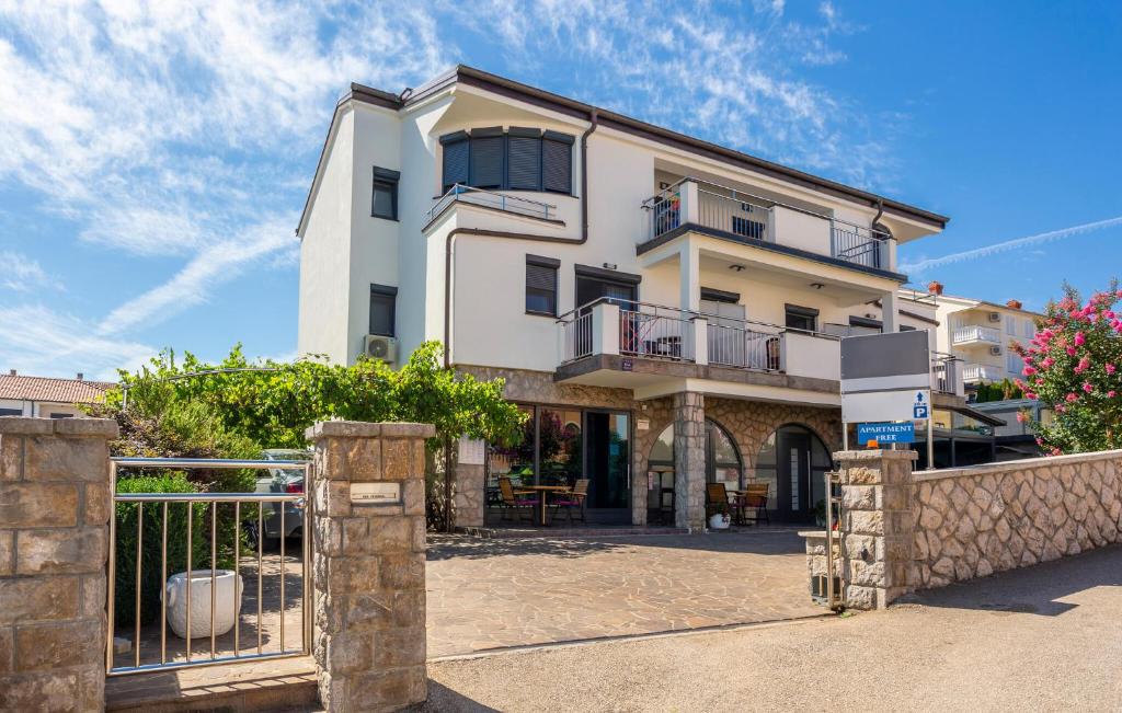 een wit gebouw met een poort ervoor bij 1 Bedroom Nice Apartment In Bogovici in Malinska
