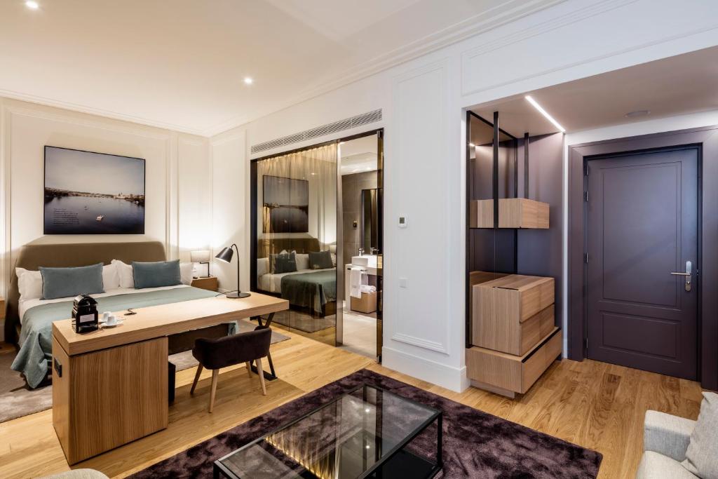 a bedroom with a bed and a desk and a room with a bed at BoHo Prague Hotel - Small Luxury Hotels in Prague