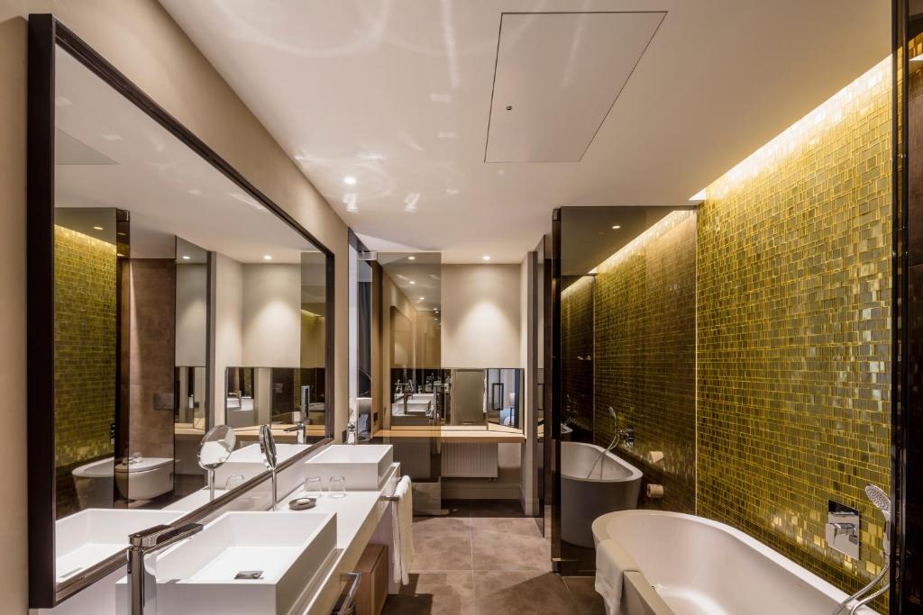 a bathroom with two sinks and a bath tub and a tubermott at BoHo Prague Hotel - Small Luxury Hotels in Prague