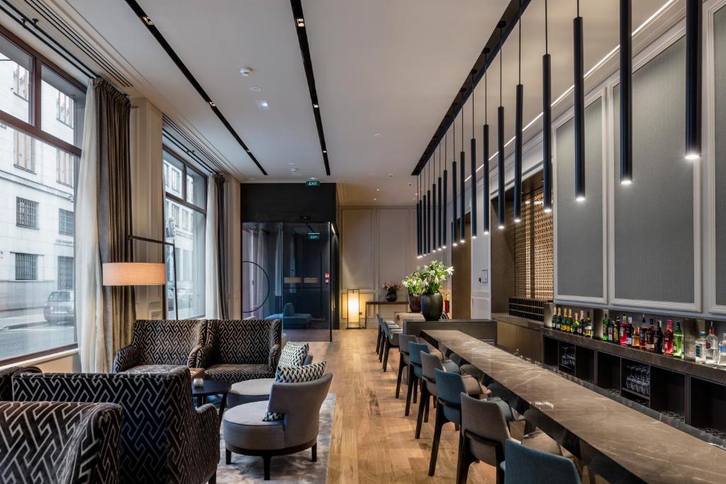 a lobby with a long bar with couches and chairs at BoHo Prague Hotel - Small Luxury Hotels in Prague