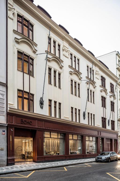 a large white building with a car parked in front of it at BoHo Prague Hotel - Small Luxury Hotels in Prague