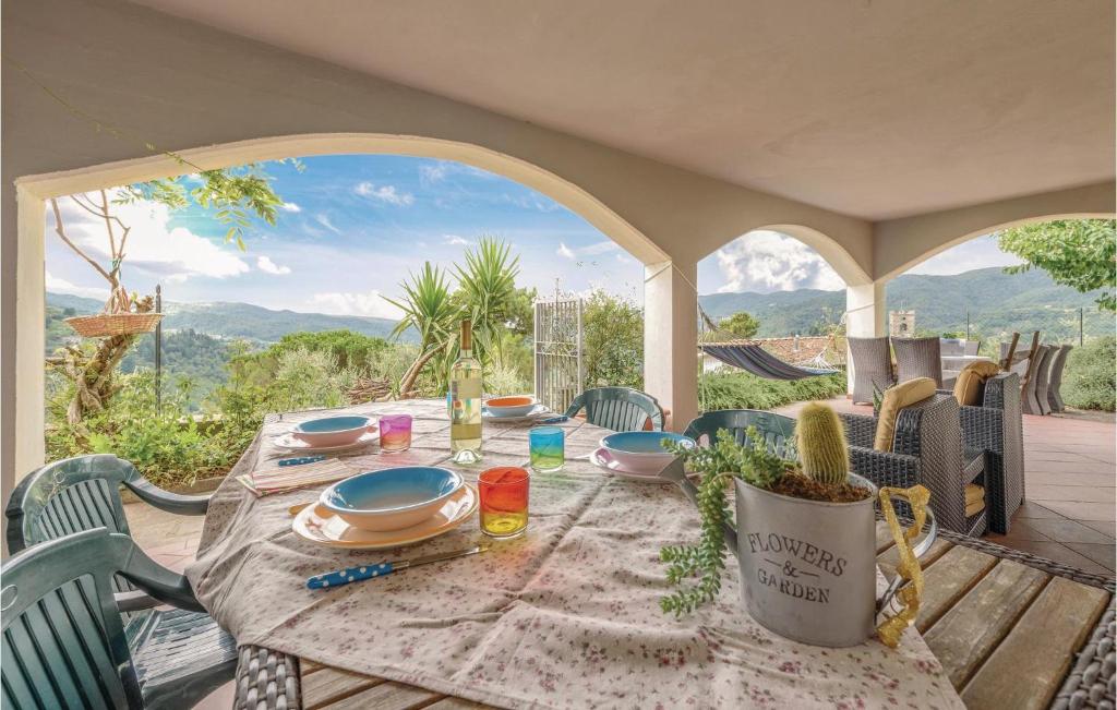 Una mesa y sillas en un porche con vista a las montañas. en Two-Bedroom Apartment In Sorana Pescia Pt, en Aramo