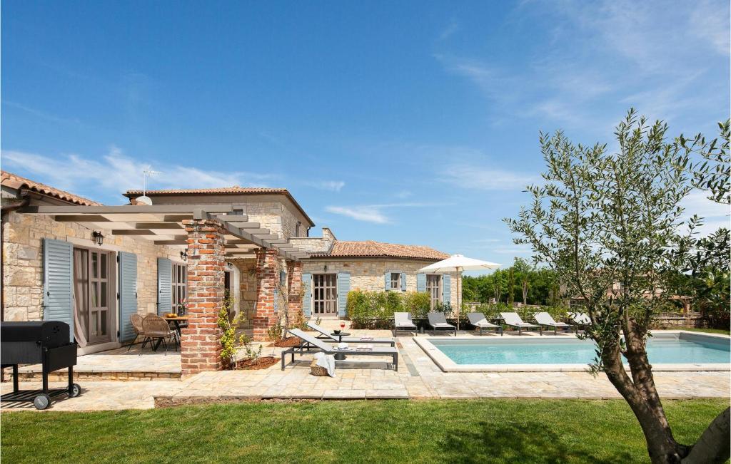 une cour arrière avec une piscine et une maison dans l'établissement Villa Adastra, à Sveti Lovreč Pazenatički