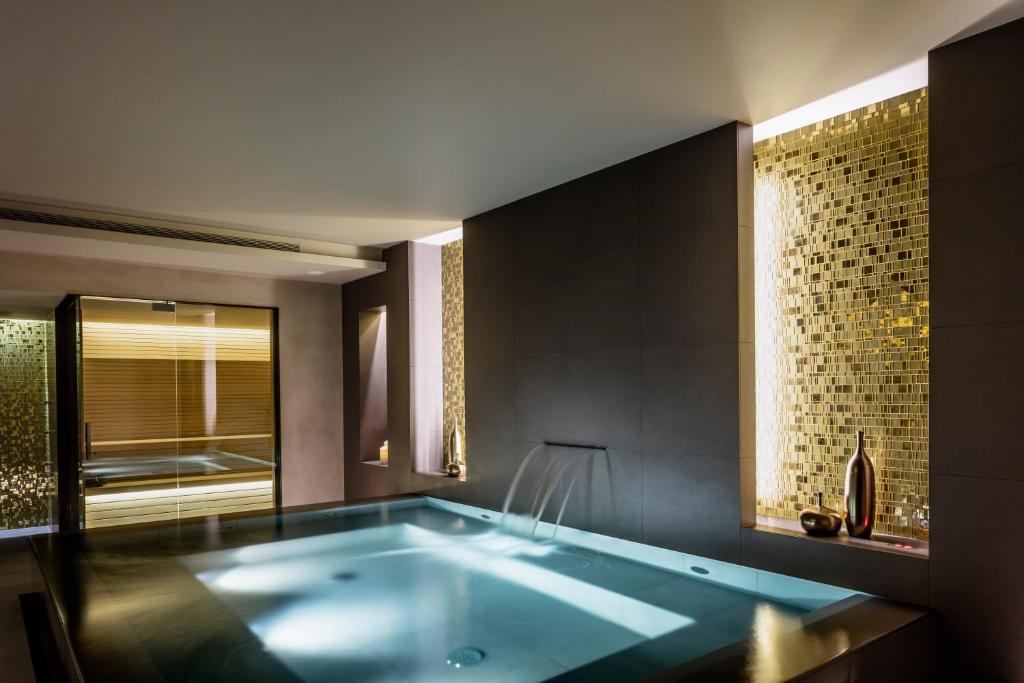 a bath tub in a bathroom with a window at BoHo Prague Hotel - Small Luxury Hotels in Prague