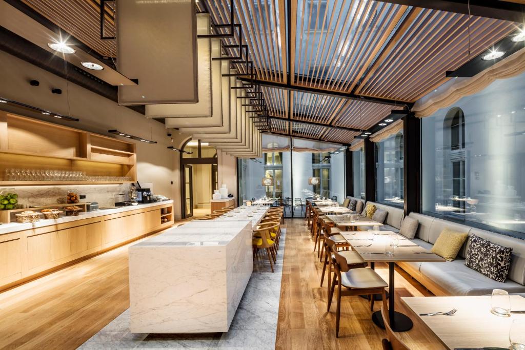 a restaurant with tables and chairs and a bar at BoHo Prague Hotel - Small Luxury Hotels in Prague