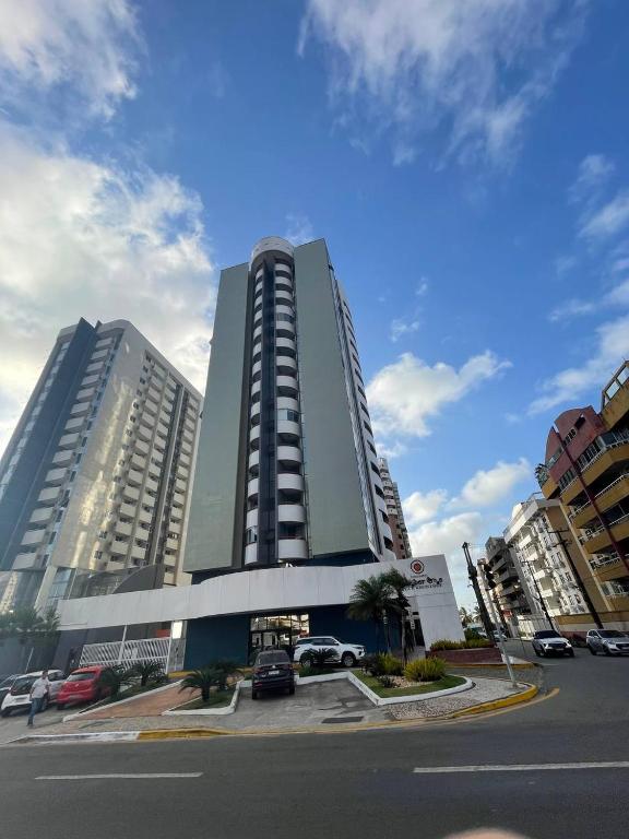 a large building with cars parked in a parking lot at Flat Number One - Fonseca Imóveis in São Luís