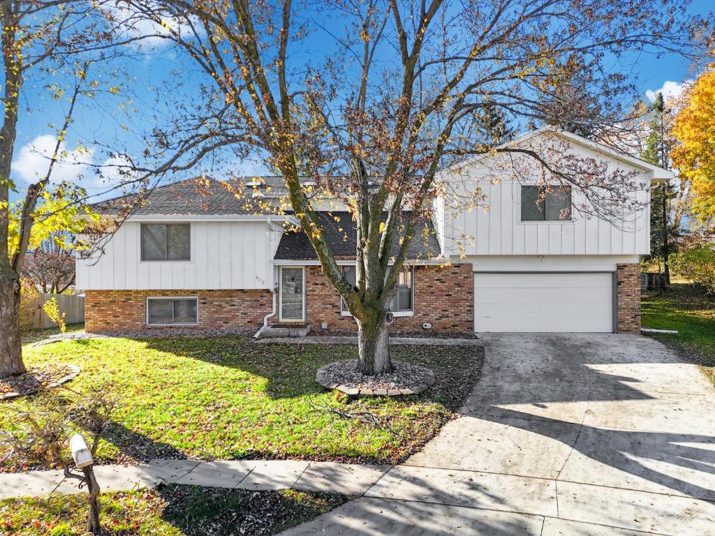 a white house with a tree and a driveway at Parkside Getaway- Spacious Six Bedroom Home for Families & Friends in Ames