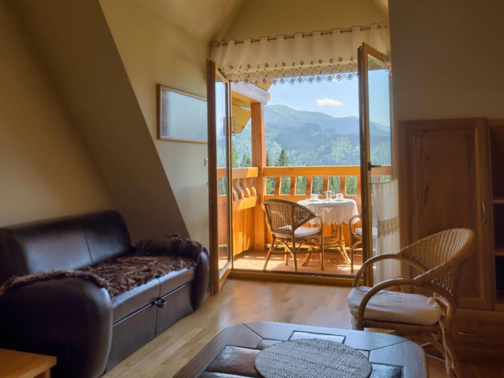 - un salon avec un canapé et une table dans l'établissement VisitZakopane - Vanilla Apartment, à Kościelisko