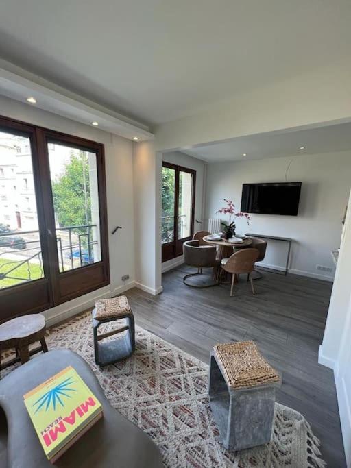 un grand salon avec une table et des chaises dans l'établissement Magnifique appartement Paris 2 chambres Tour Eiffel, à Paris