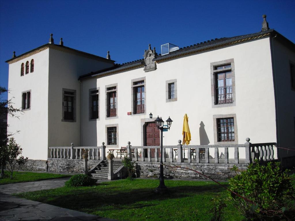 a white building with a fence in front of it at Pazo Torre Do Barrio in Loseiro