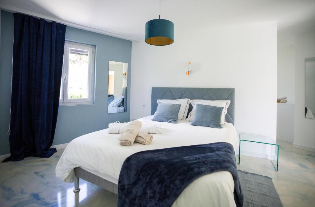 a bedroom with a large white bed with blue walls at NUXIA Suites&SPA - L'Art Design in Bagnols-sur-Cèze