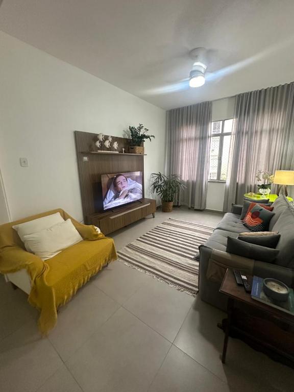 Hotel Espaçoso apartamento reformado em Copacabana, a living room with a couch and a flat screen tv at Espaçoso apartamento reformado em Copacabana in Rio de Janeiro