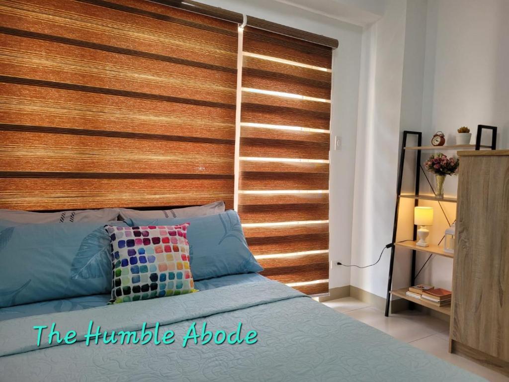 a bed with a wooden headboard in a bedroom at The Humble Abode in Tagaytay