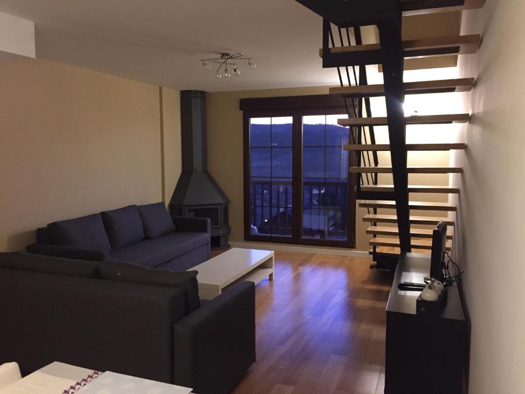 Residencial Ribes- Massana في الكالا دي لا سيلفا: غرفة معيشة مع أريكة زرقاء ومدفأة