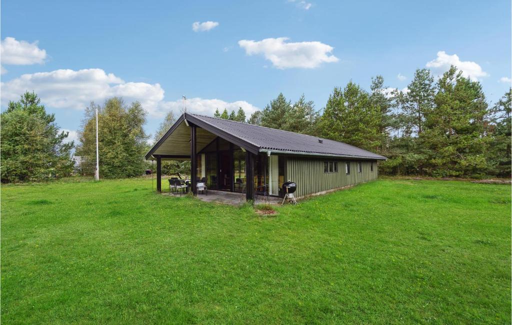 un piccolo edificio in un prato alberato di Three-Bedroom Holiday Home In Jerup a Jerup