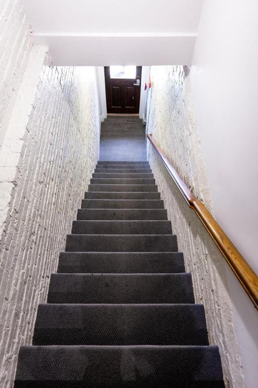 a stairway leading up to a door in a building at West Broadway Quarters by Thatch in Boston